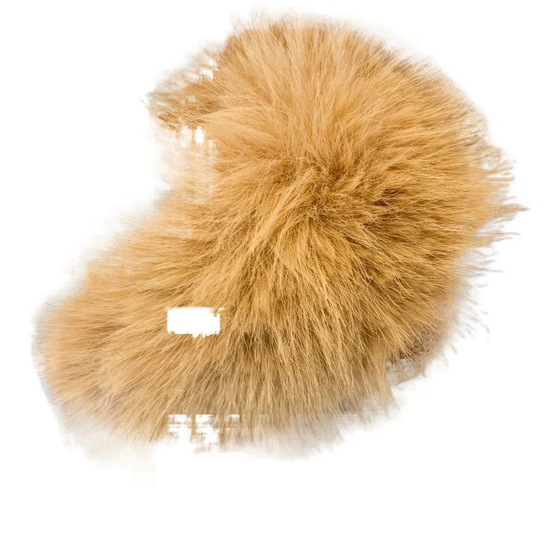 Close-up of a fluffy, light brown faux fur pom pom accessory on white background