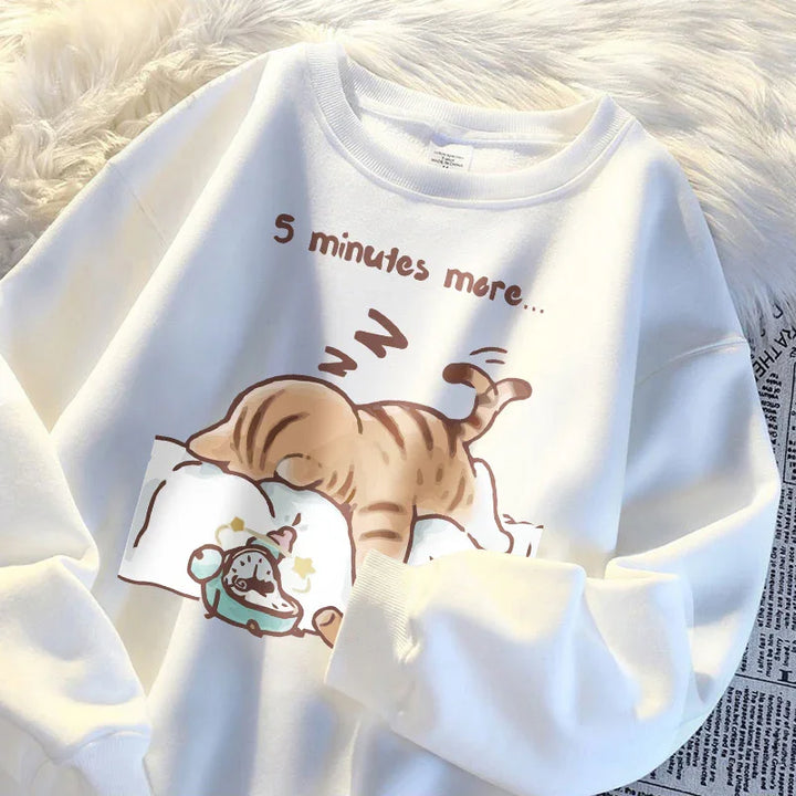 White sweatshirt featuring cartoon of a sleeping brown tabby cat with alarm clock and text '5 minutes more'