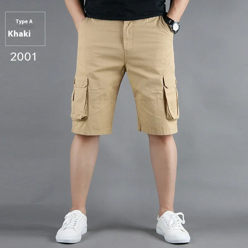 Man wearing khaki cargo shorts with flap pockets and white sneakers against gray background