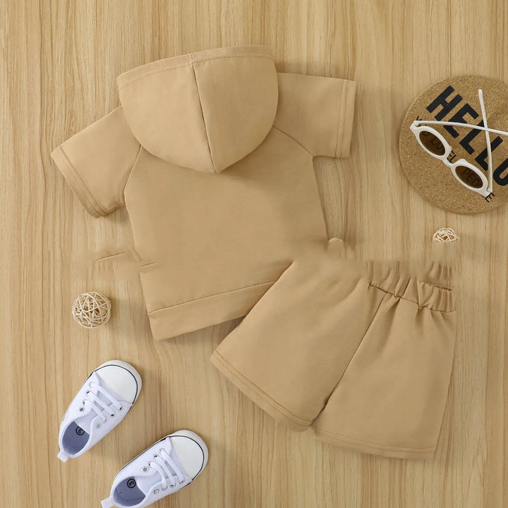 Beige toddler hooded short sleeve top and elastic waistband shorts set on wooden floor
