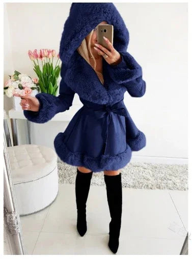 Woman wearing navy blue faux fur hooded coat with belt and black thigh-high boots indoors
