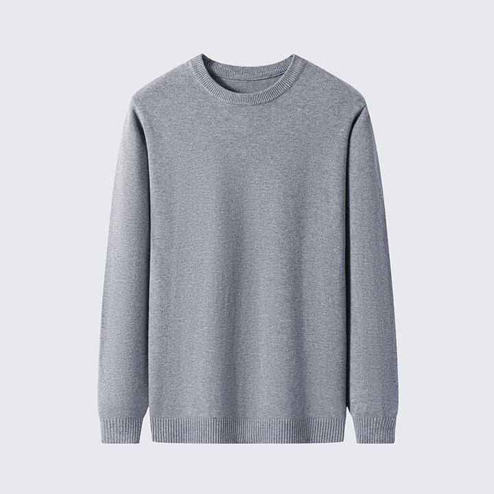 Simple grey crewneck sweater with long sleeves, ribbed cuffs and hem, plain background