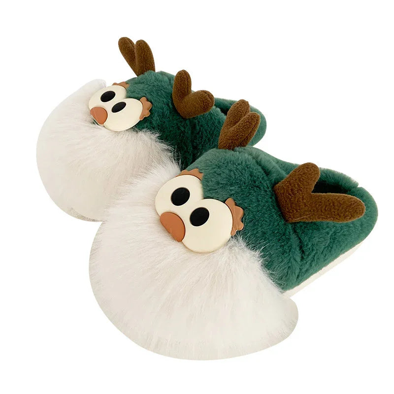 Green plush slippers with cartoon reindeer faces and brown antlers on white background