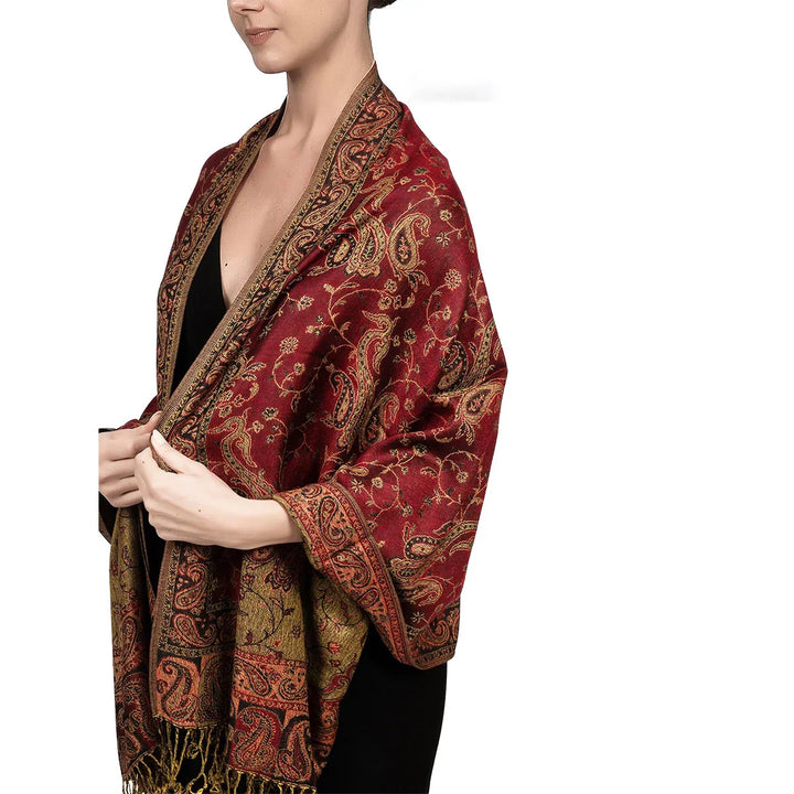 Woman wearing red paisley-patterned shawl with gold and black details over black dress