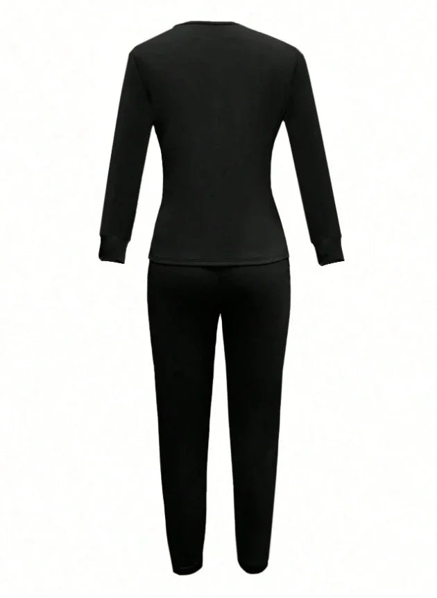 Back view of black long-sleeve top and matching black pants set on white background