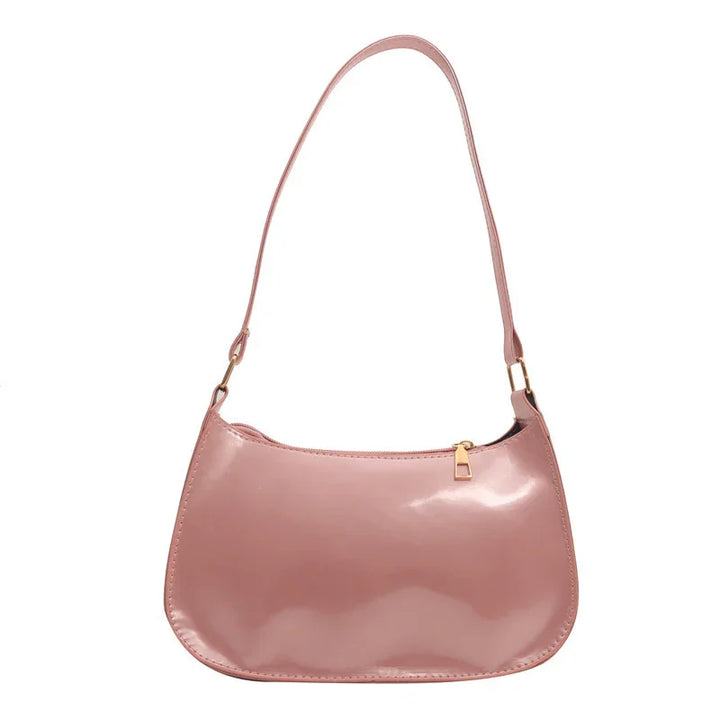 Glossy light pink leather shoulder bag with gold zipper and adjustable strap