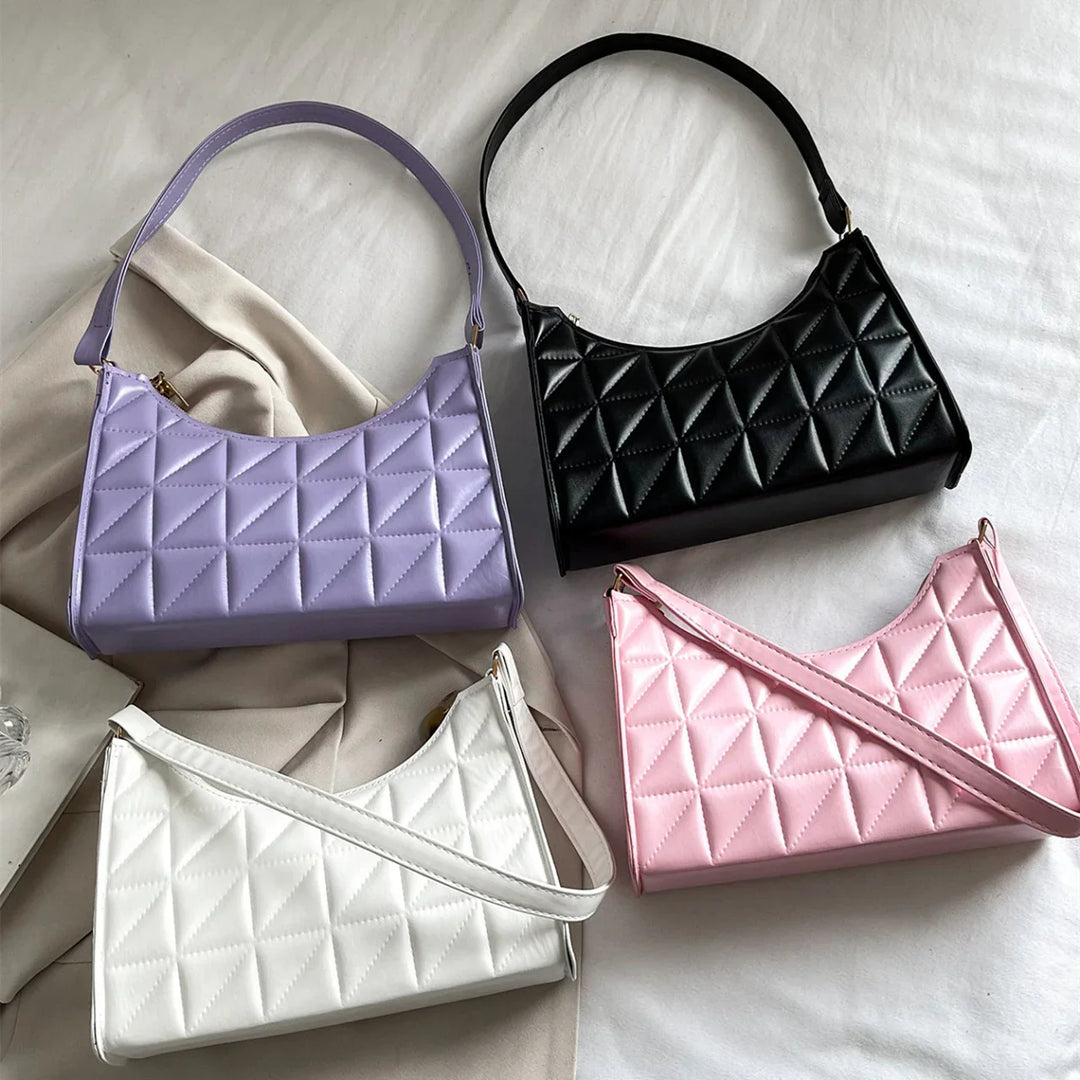 Four quilted leather handbags in black, lavender, white, and pink on white fabric background