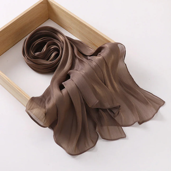 Brown sheer silk chiffon scarf artfully draped inside wooden display frame on white background
