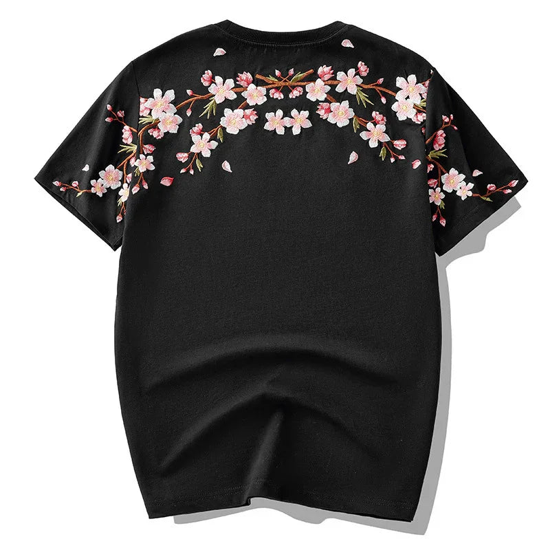 Black short-sleeve t-shirt with pink cherry blossom floral embroidery across shoulders and sleeves