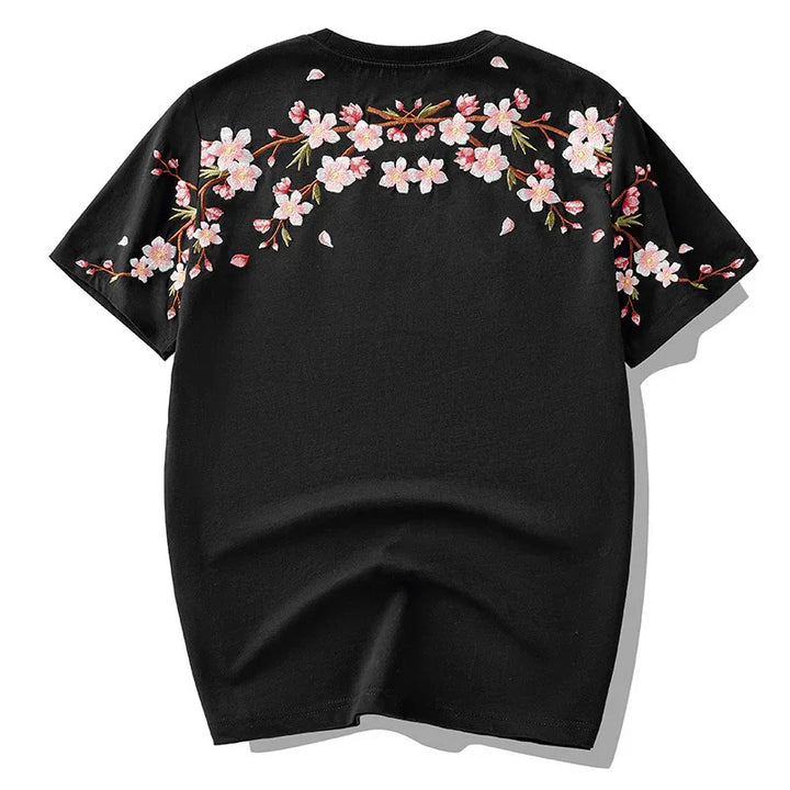 Black short-sleeve t-shirt with pink cherry blossom floral embroidery across shoulders and sleeves