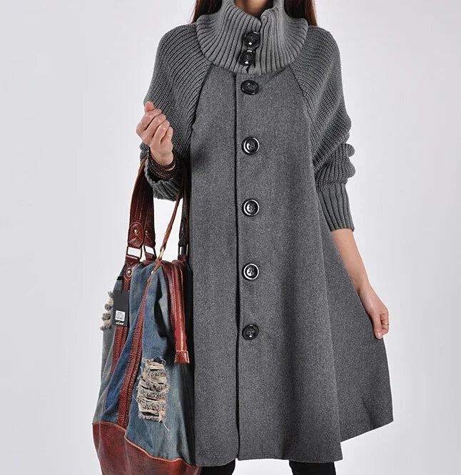 Woman wearing a grey wool coat with buttons and knitted sleeves, holding a denim and leather tote bag