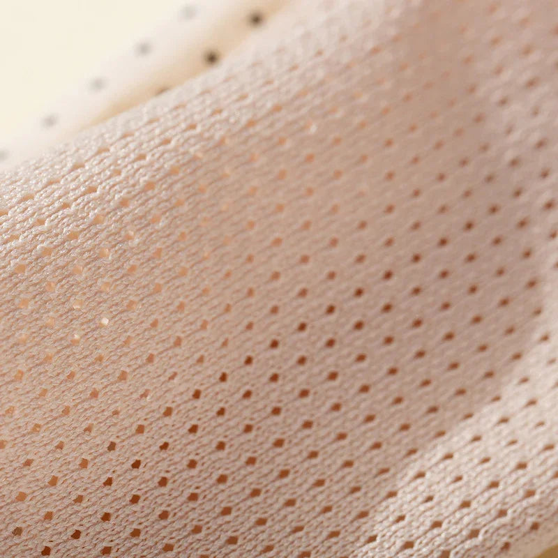 Close-up of beige perforated breathable fabric with textured details
