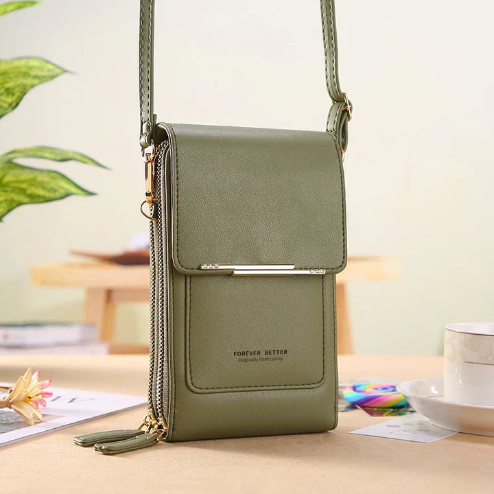 Olive green leather crossbody bag with flap closure and gold accents on wooden table