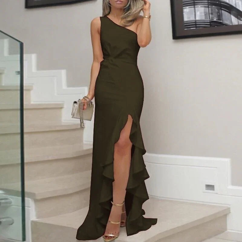 Woman in one-shoulder black evening gown with thigh-high slit and ruffle detail on staircase