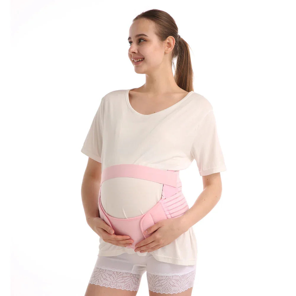 Smiling pregnant woman wearing white shirt and pink maternity support belt with lace shorts