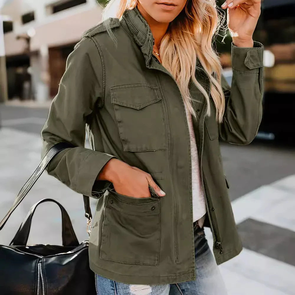 Woman wearing olive green utility jacket with large pockets and zipper, carrying black leather bag