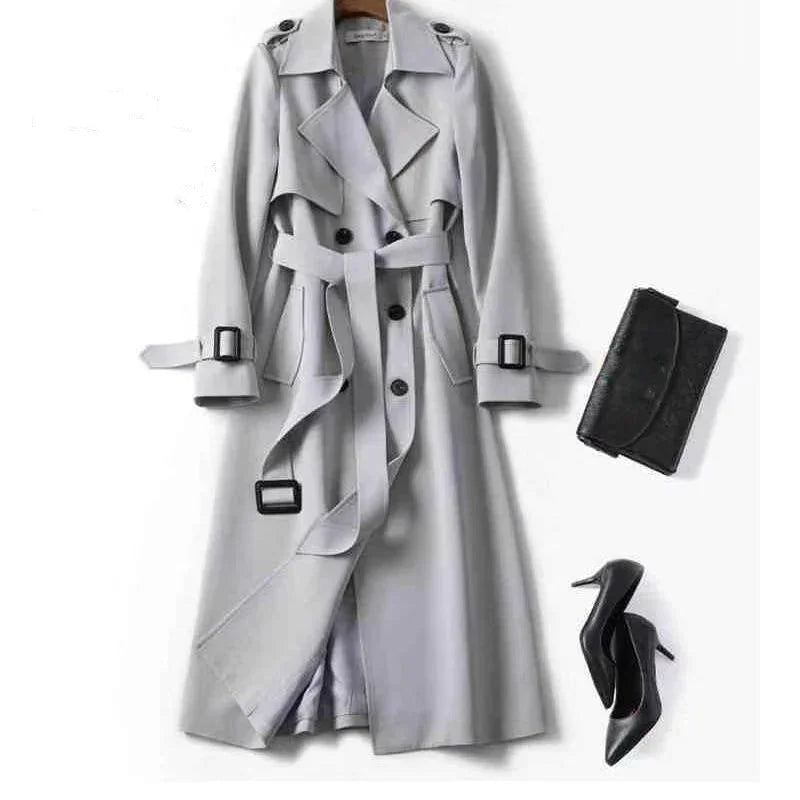 Light gray double-breasted trench coat with belt, black buckle details, paired with black high heels and black clutch bag