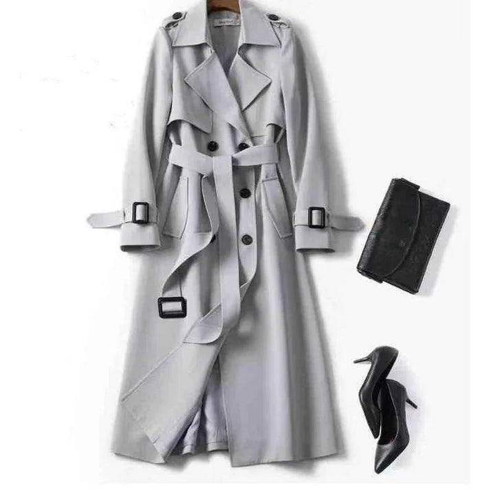 Light gray double-breasted trench coat with belt, black buckle details, paired with black high heels and black clutch bag