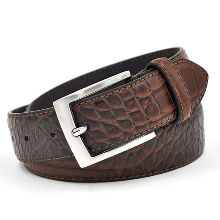 Brown crocodile textured leather belt with silver rectangular buckle on white background