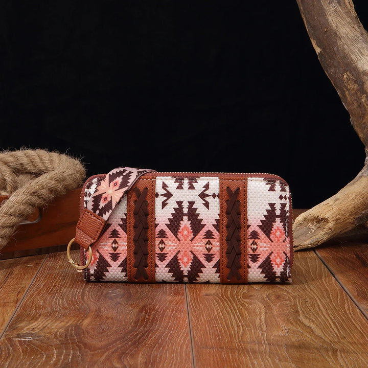 Southwestern patterned wristlet clutch with pink and brown geometric design on wooden surface