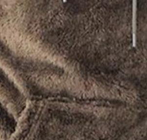 Close-up of brown textured faux fur fabric with visible seam stitching