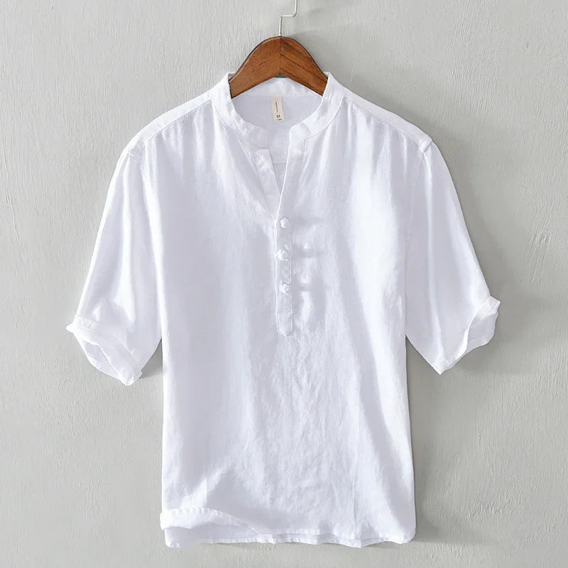 White short sleeve mandarin collar shirt with button placket on wooden hanger against gray wall