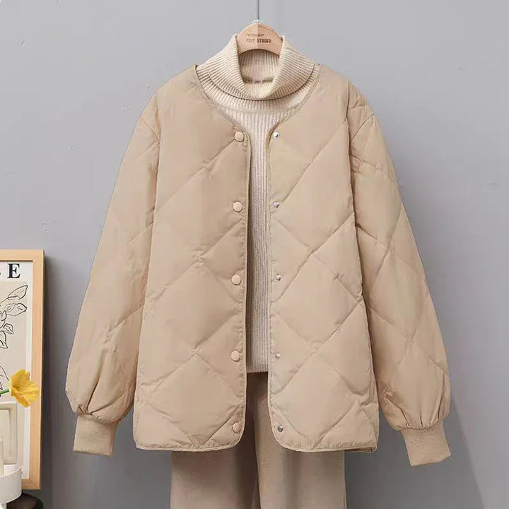 Beige quilted bomber jacket paired with cream turtleneck sweater and beige pants