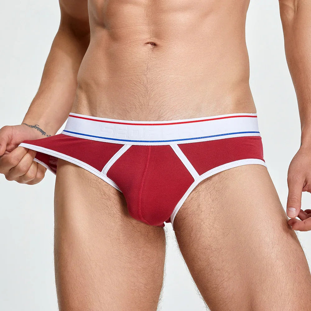 Close-up of a man wearing red briefs with white trim and a white waistband with red and blue stripes