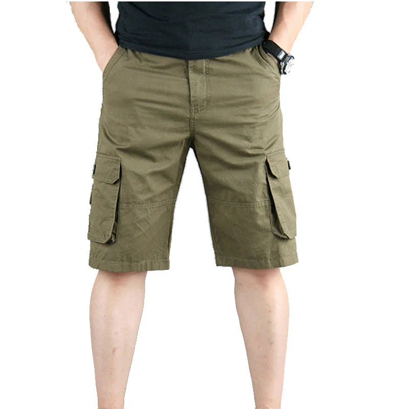 Man wearing olive green cargo shorts with side pockets against white background