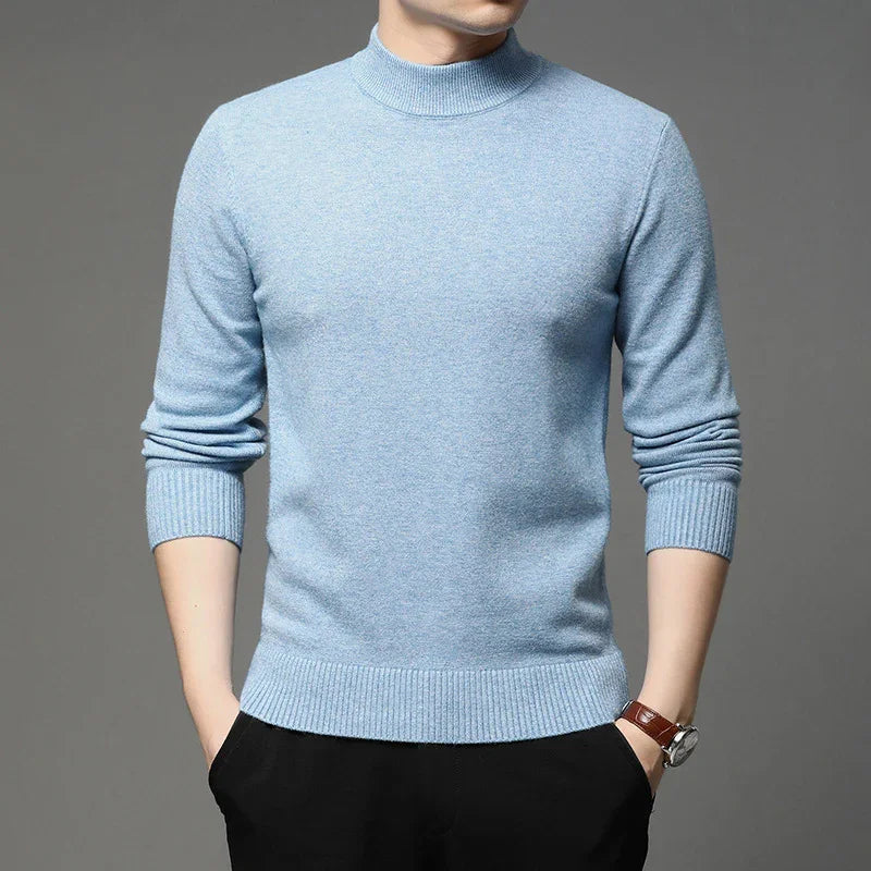 Man wearing light blue mock neck sweater with ribbed cuffs and hem, paired with black pants and a wristwatch