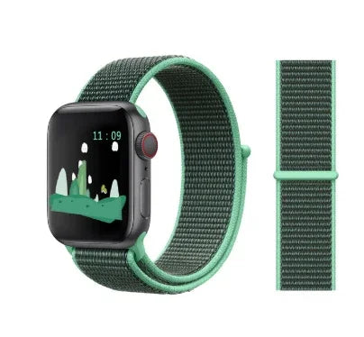 Smartwatch with a green and black woven nylon band showing a mountain landscape on the screen