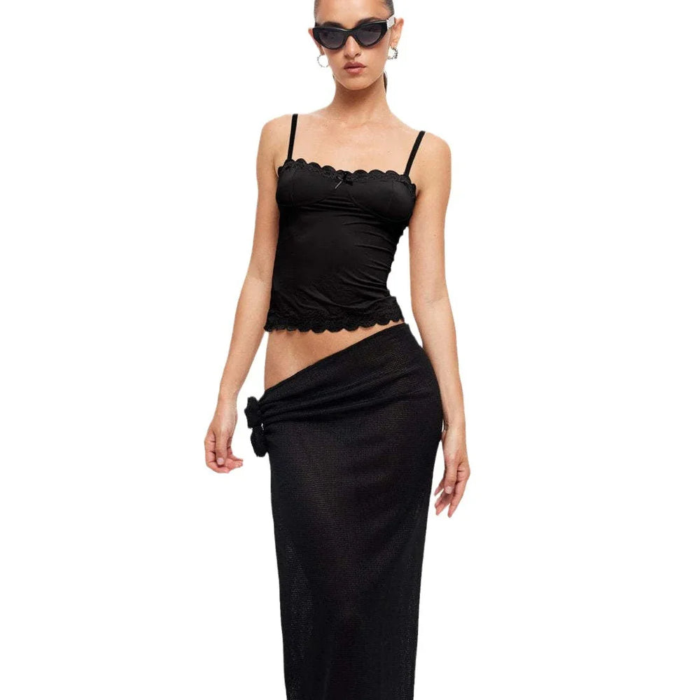 woman wearing black lace trim camisole top and matching black high-waisted skirt with knot detail