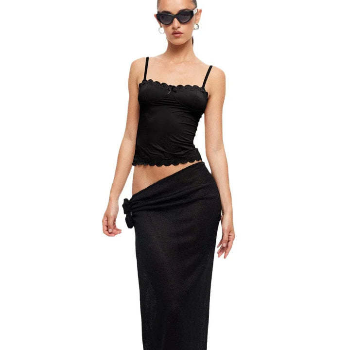 woman wearing black lace trim camisole top and matching black high-waisted skirt with knot detail