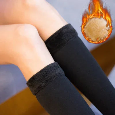 Close-up of legs wearing black fleece-lined leggings with fire graphic indicating warmth