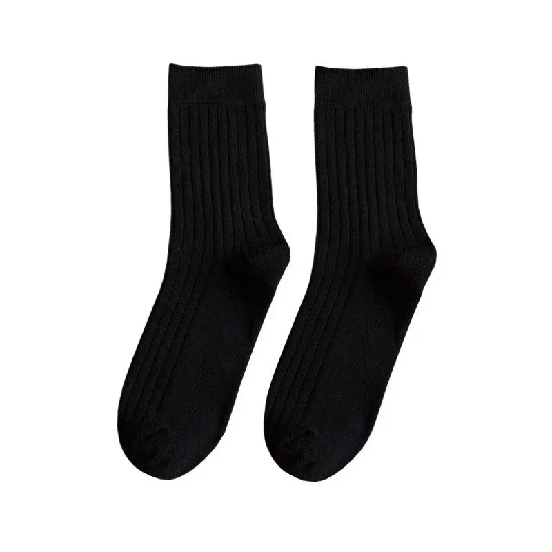 Pair of black ribbed crew socks on white background, comfortable cotton blend