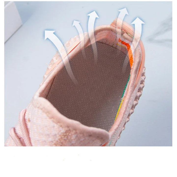 Close-up of breathable pink sneaker interior showing ventilation arrows for airflow