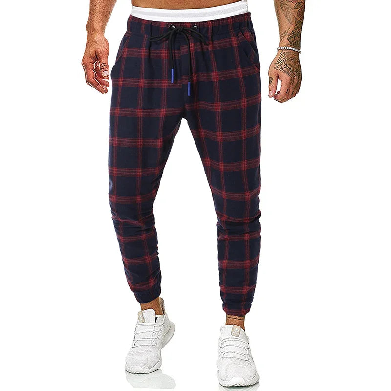 Mens navy blue and red plaid jogger pants with white drawstring waistband and white sneakers