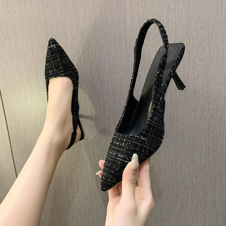 Pair of black textured pointed toe slingback heels with mid-height stiletto heel
