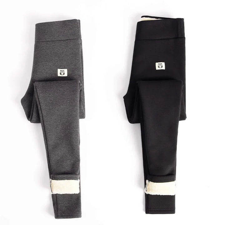 Folded grey and black fleece-lined leggings with small owl logo patches on white background