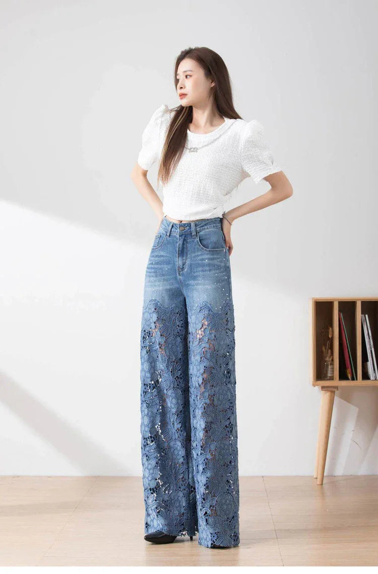 Woman wearing white puff sleeve top and blue high-waisted wide-leg lace cutout denim jeans in a minimalist room