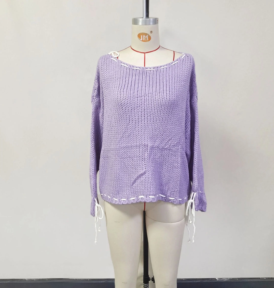 Lavender purple chunky knit sweater with white lace-up details on neckline, hem, and sleeves on mannequin
