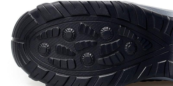 Close-up of black durable shoe sole with circular and rectangular tread patterns for traction