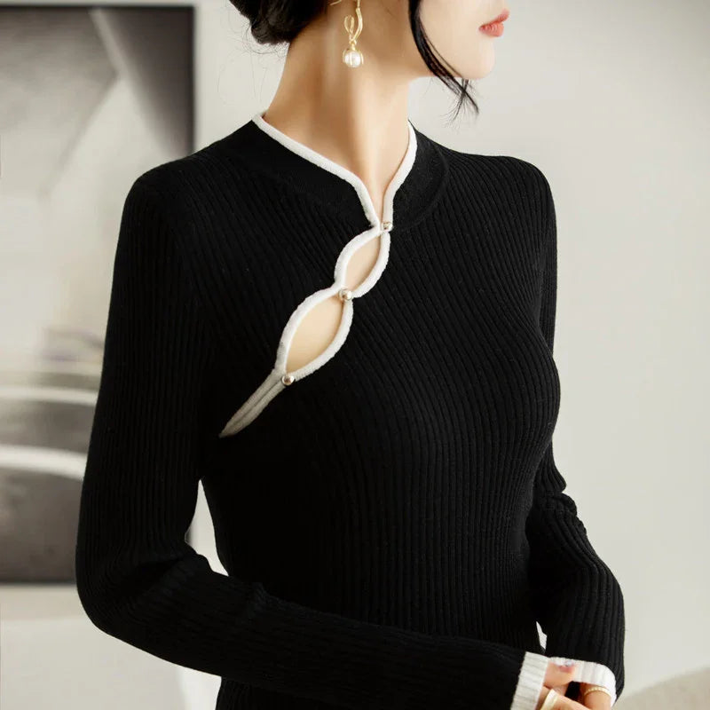 Black ribbed knit sweater with white trim and decorative keyhole cutouts on chest