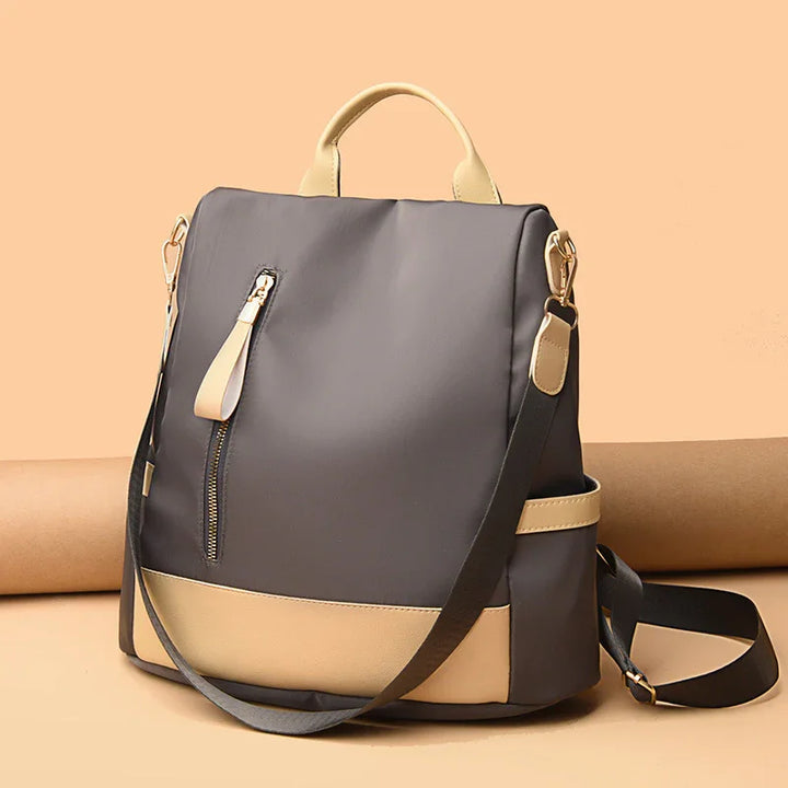 Modern gray and beige backpack with front zipper pocket and adjustable shoulder strap