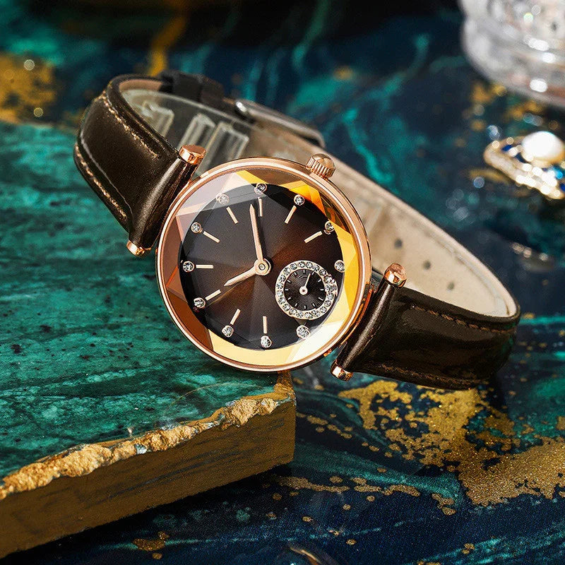 Elegant wristwatch with black dial, crystal hour markers, rose gold bezel, and black leather strap on textured blue surface
