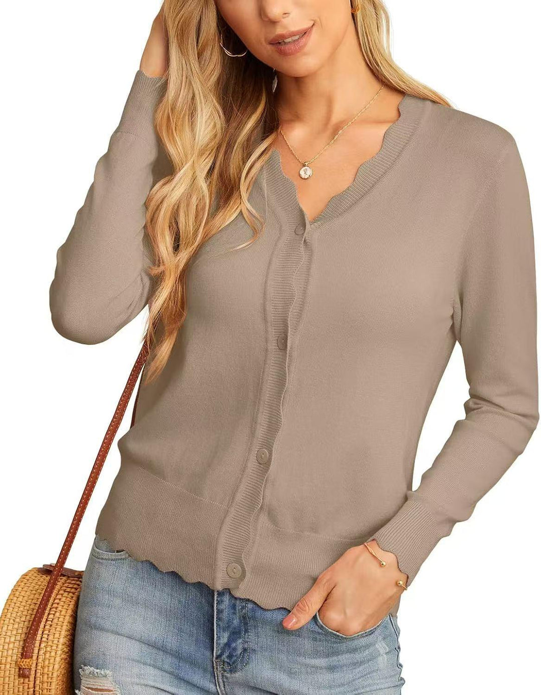 Woman wearing beige scallop trim button-up cardigan with ripped light blue jeans and straw bag