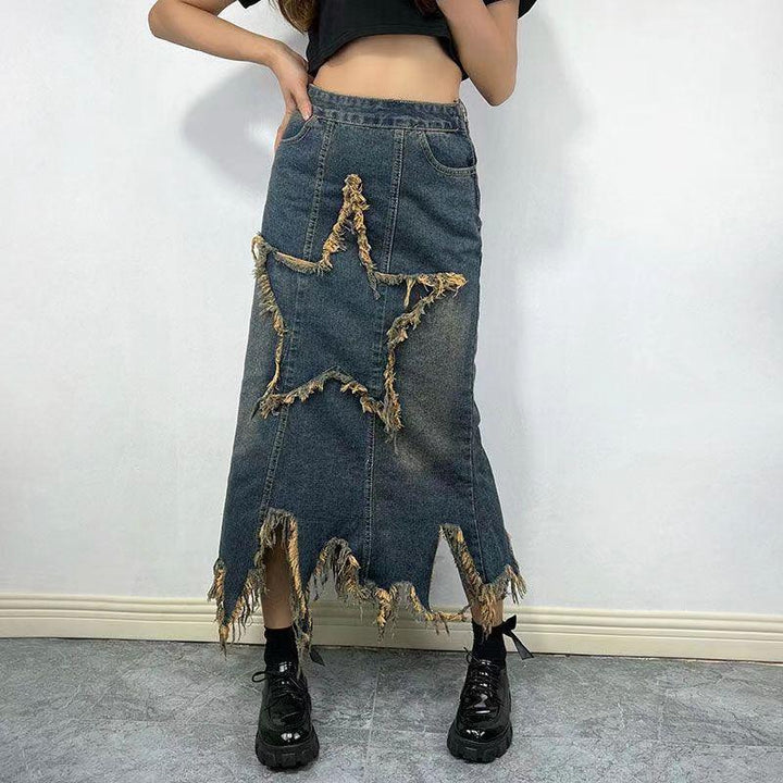Denim midi skirt with frayed star design and jagged hem worn with black shoes and crop top