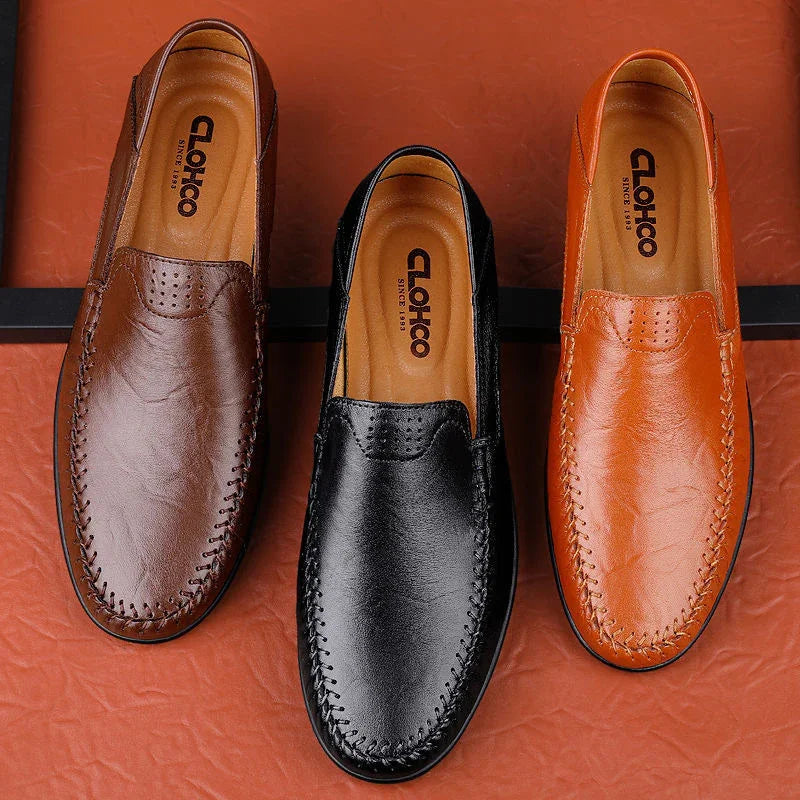 Three leather loafers in brown, black, and tan on a brown surface, branded Clokho shoes