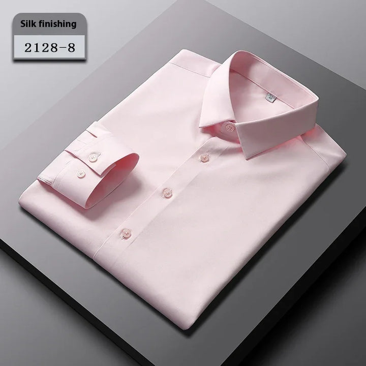Folded light pink silk-finished dress shirt with buttons on gray surface, labeled 2128-8