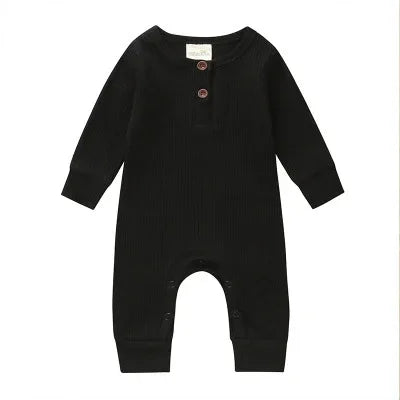 Black ribbed baby romper with long sleeves, two brown buttons on chest, and snap closures at legs